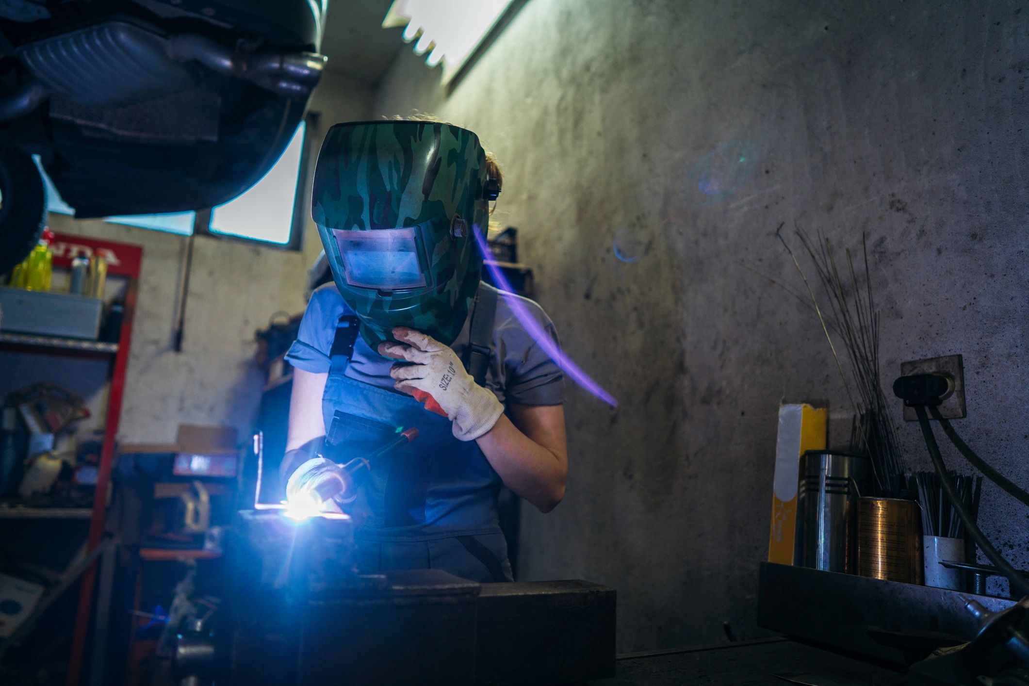 Female mechanic welding metal