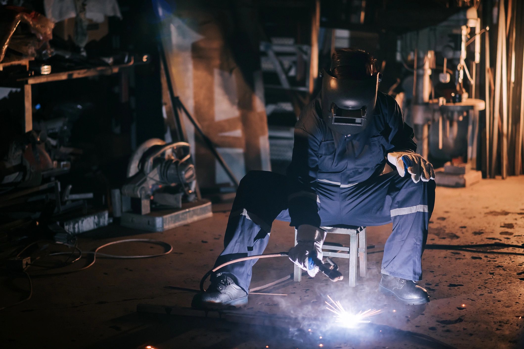 Asian chinese female welder working with welding torch in the workshop