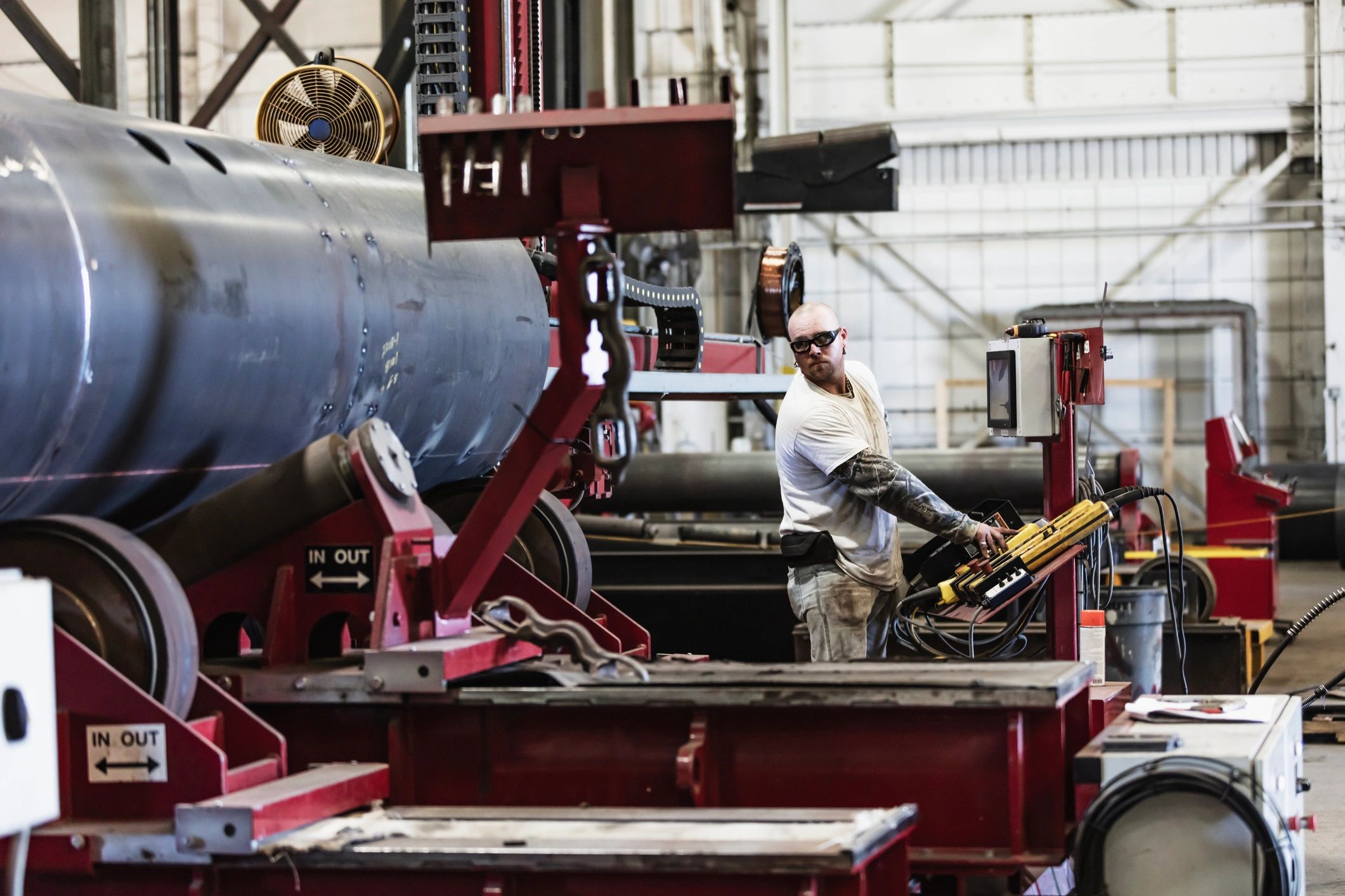 Metal fabricator uses automatic welding torch in factory